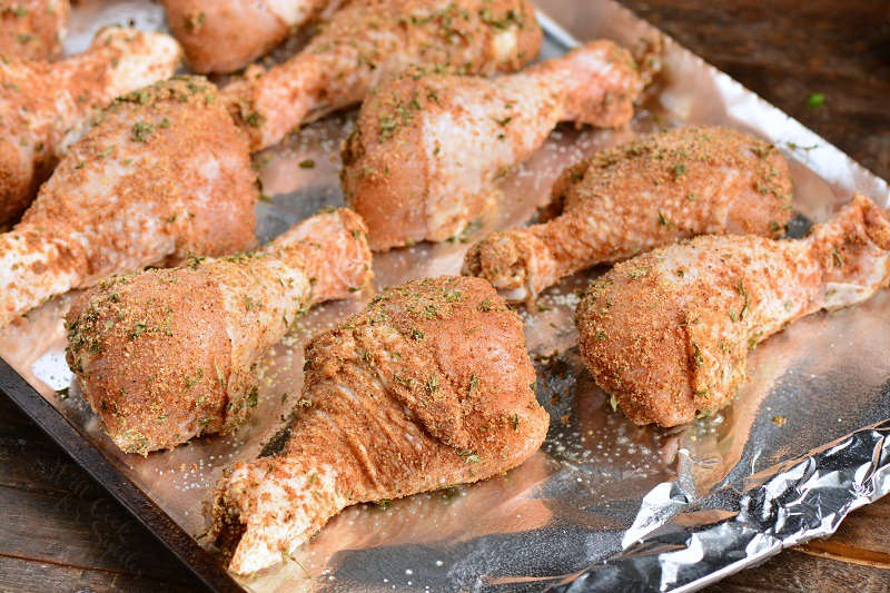 raw chicken drumsticks on a cookie sheet lined in tin foil 
