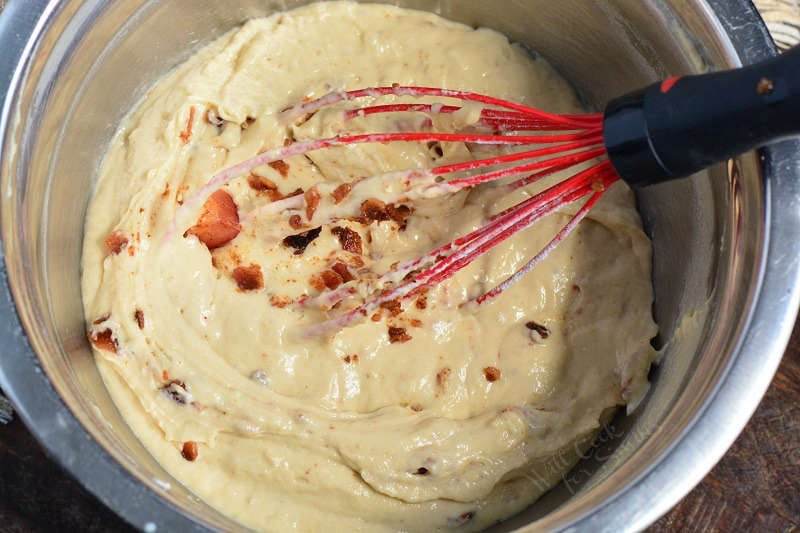 donut batter in a metal bowl with a whisk 