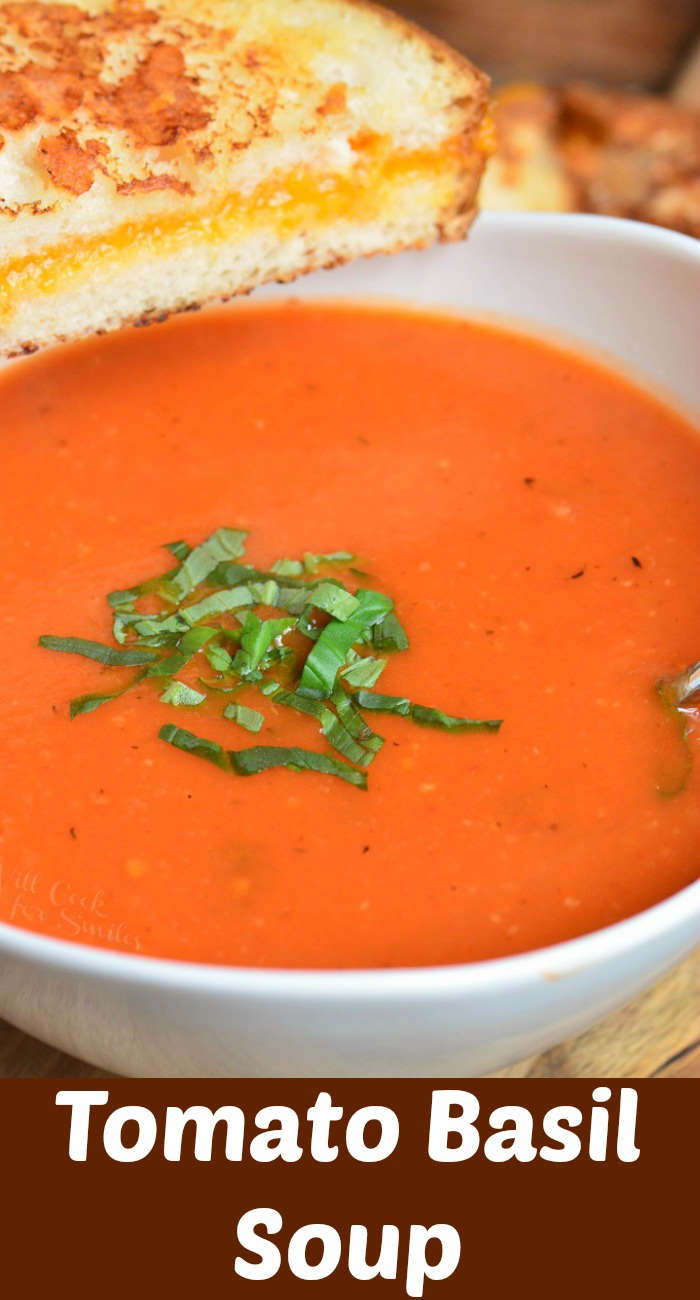 closeup of tomato soup in a white bowl with grilled cheese and basil and title on the bottom