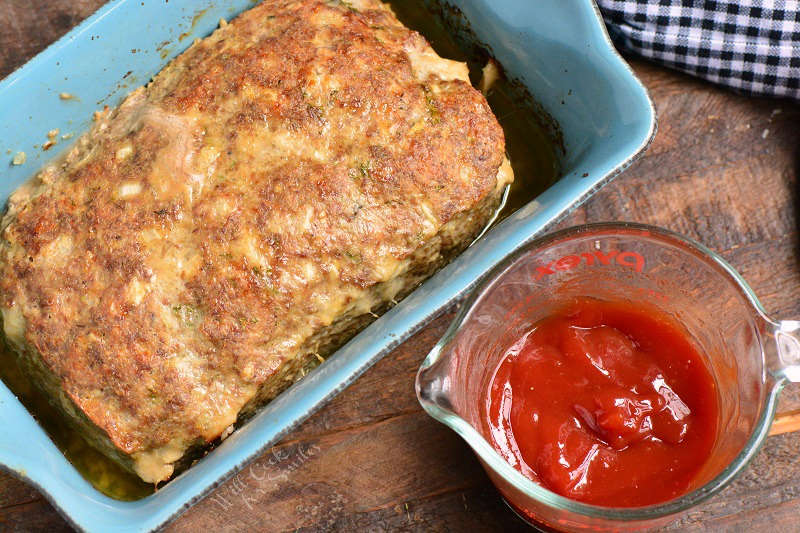 baked meatloaf and ketchup sauce in measuring cup.