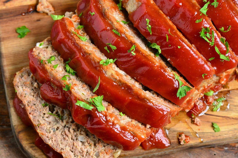 closeup of sliced meatloaf from the top on the cutting board.