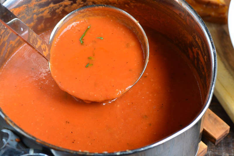 silver ladle coming out of the pot scooping some of the soup