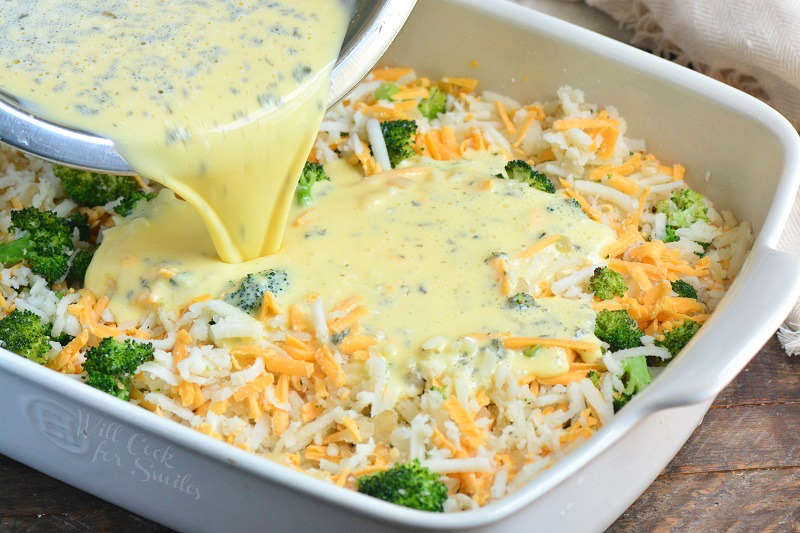 pouring egg over casserole that is in a baking pan 