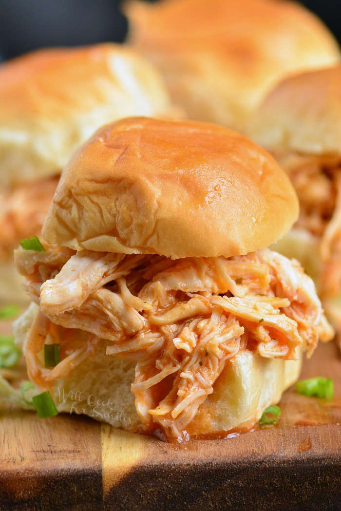 shredded buffalo chicken sandwich on a cutting board 