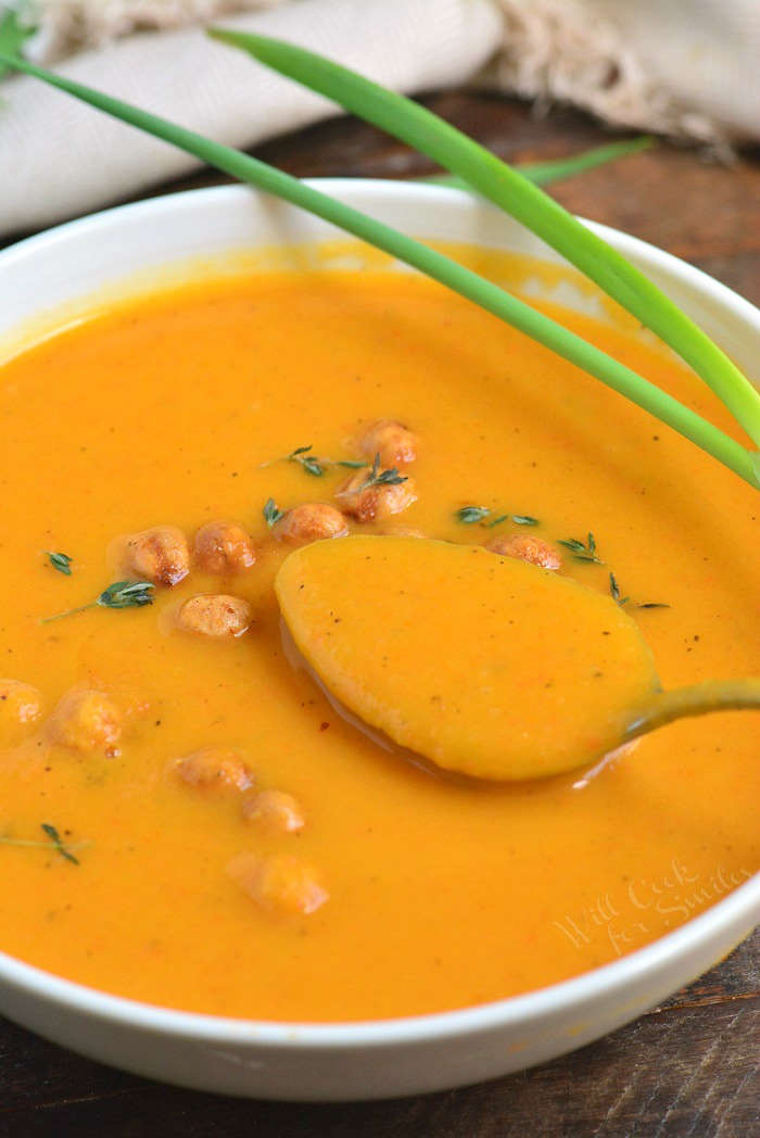 Spoonful of butternut squash soup that is in a bowl 