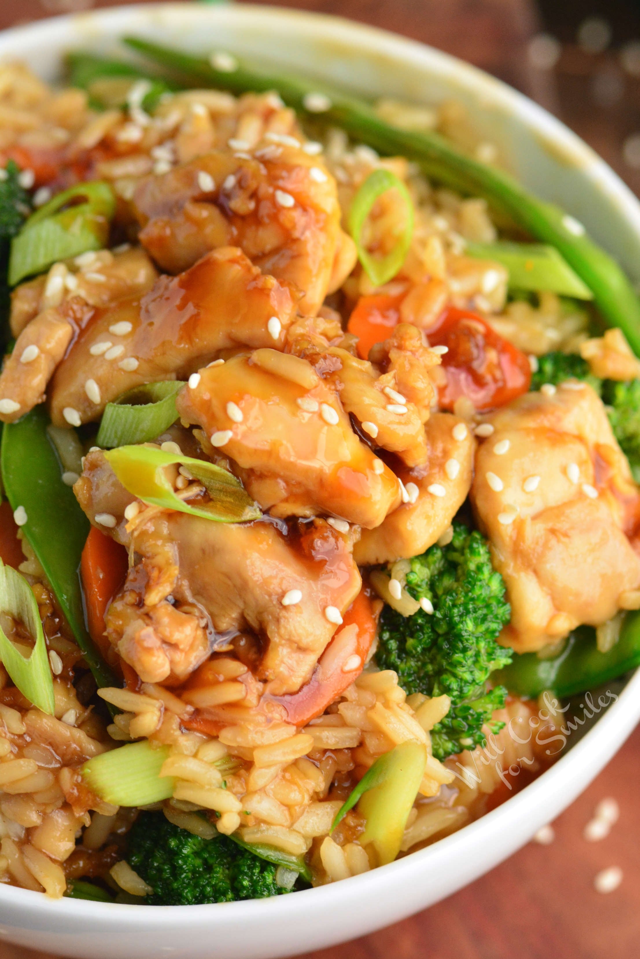 a big bowl full of chicken teriyaki rice and vegetables.