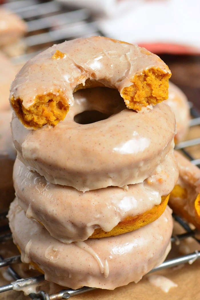 pumpkin donuts stacked up on a cooling rack top on cut in half 