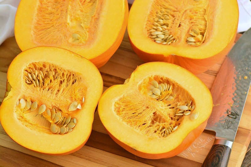 sugar pumpkins cut in half on the cutting board. 