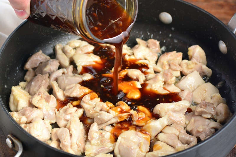 adding teriyaki sauce to pan with chicken