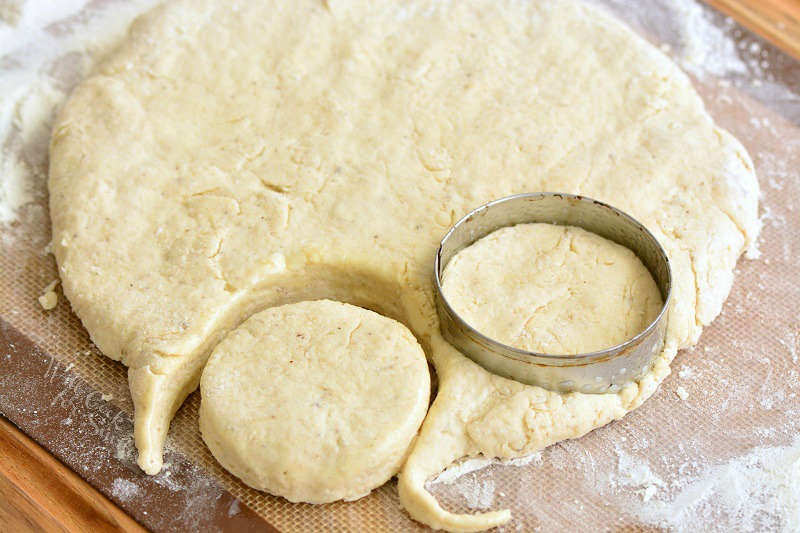 biscuit dough in a circle with two cut out biscuits