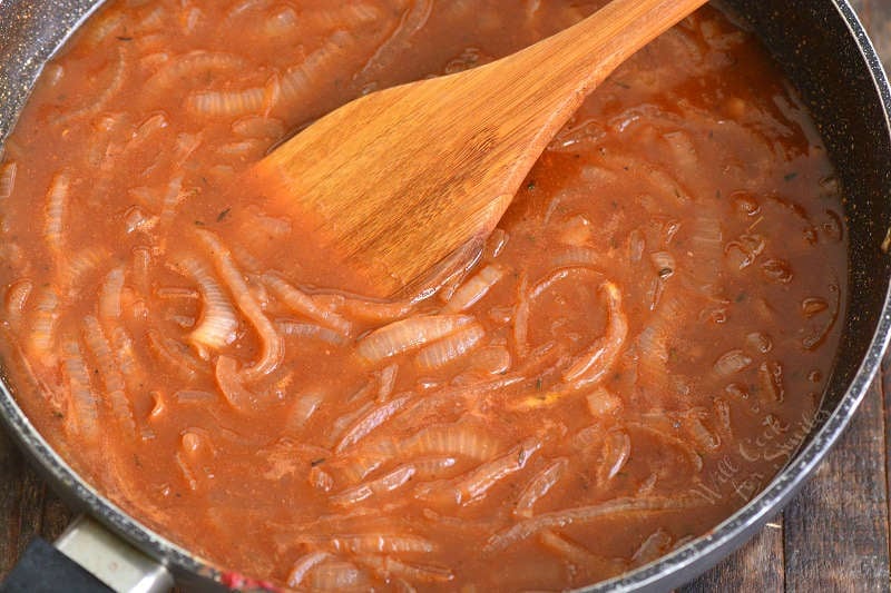 french onion sauce in the pan with a wooden spoon 