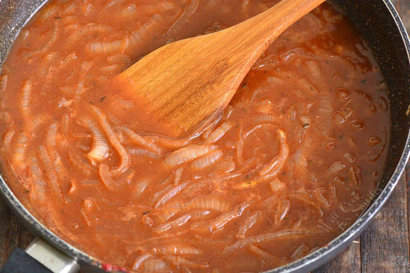 french onion sauce in the pan with a wooden spoon 