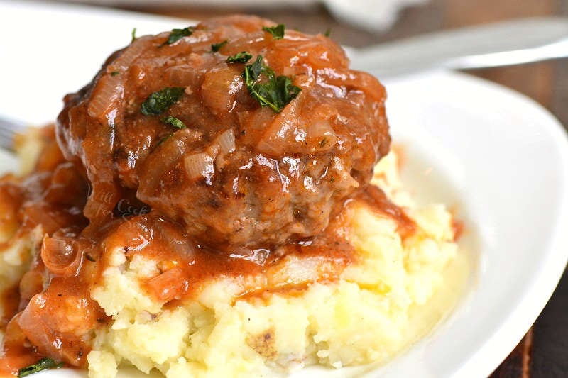 saliabury steak over mashed potatoes on a plate 