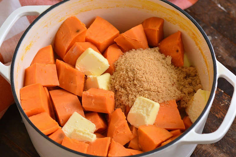 cooked sweet potatoes with butter, sugar, milk, and eggs in a pot 
