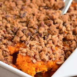 scooping out some sweet potato casserole from the dish.