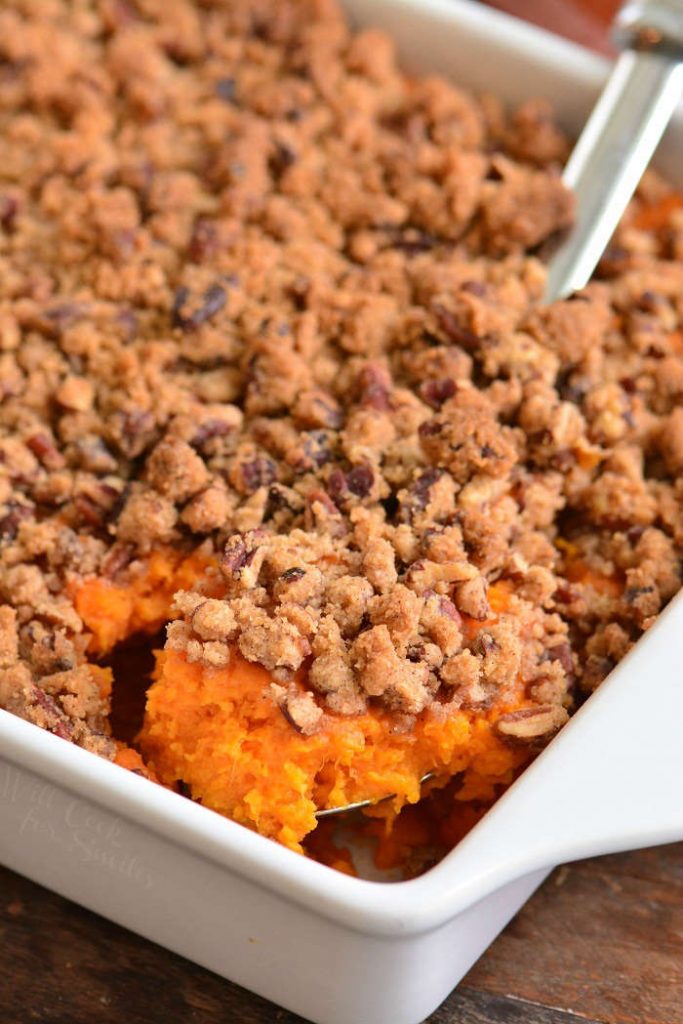 scooping out some sweet potato casserole from the dish.