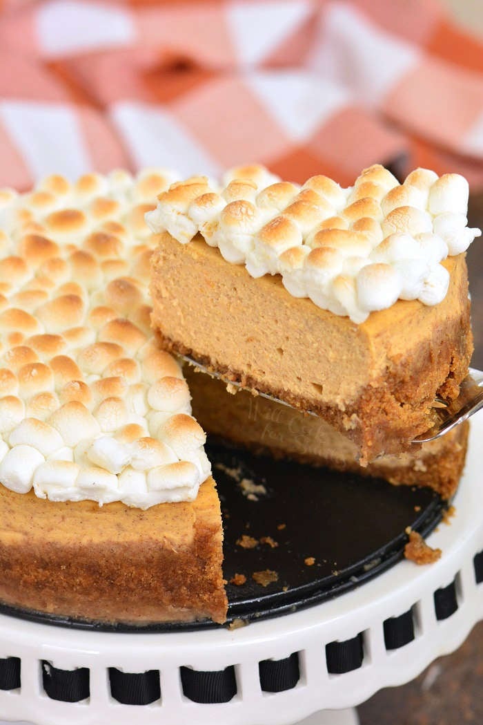 slicing sweet potato cheesecake on a cake stand 