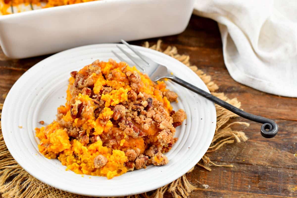 sweet potato casserole on a white plate with a fork.