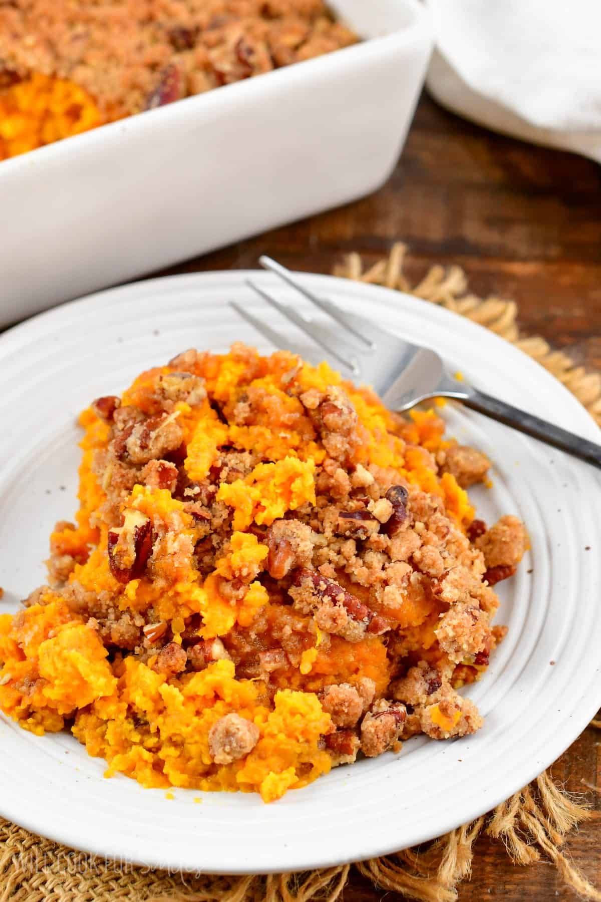 portion of a sweet potato casserole with a pecan crumble topping.
