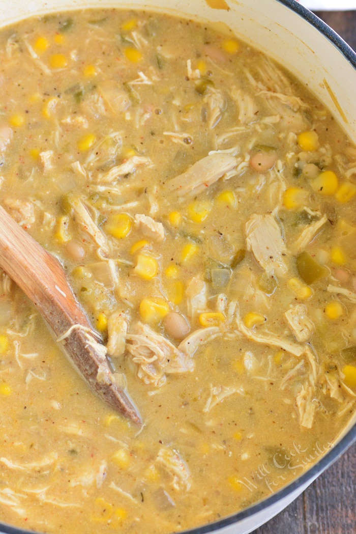 White chicken chili in pit with wooden spoon 