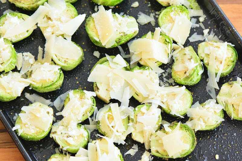 brussels sprouts with parmesan cheese on top on a baking sheet 