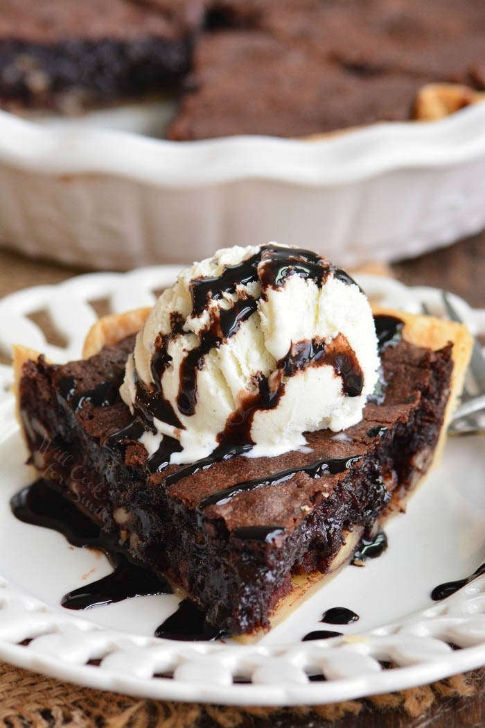 brownie pie with a scoop of ice cream and chocolate sauce on a plate 