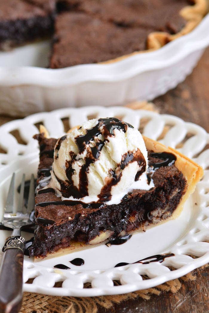 brownie pie with a scoop of ice cream and chocolate sauce on a plate 