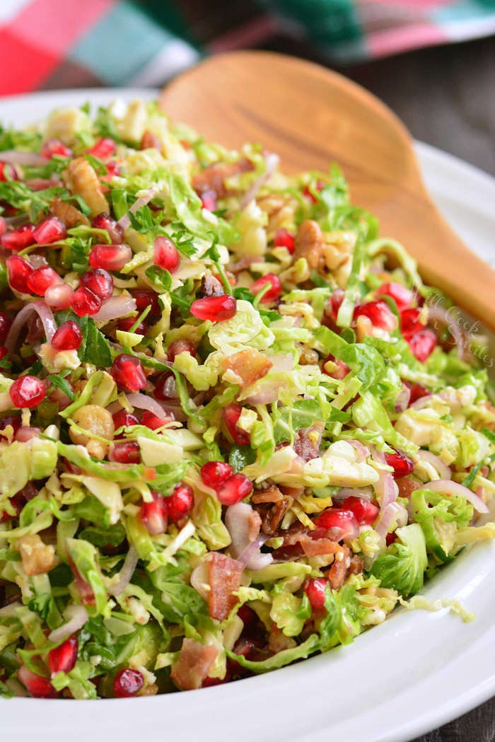 Brussels sprouts salad in a bowl with a wooden spoon 