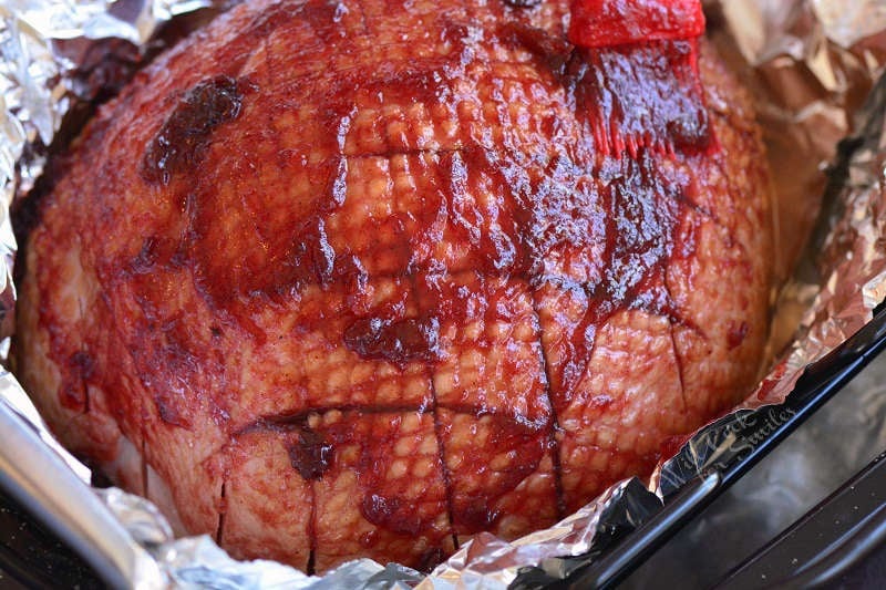 glazed ham in a roasting pan lined in tin foil 