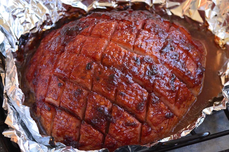baked ham in foil with glaze on.