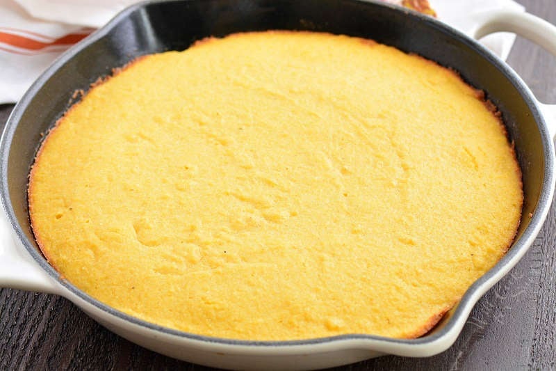 cooked cornbread in a white cast iron skillet