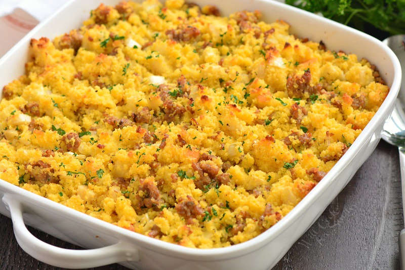 cornbread dressing in a casserole dish on a wood table 