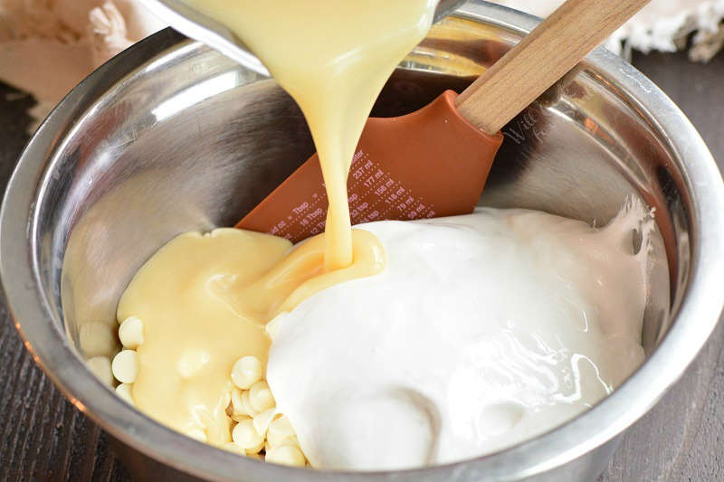 pouring hot sweetened condensed milk into chocolate