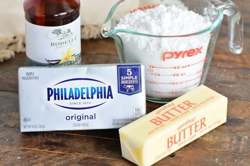 ingredients for cream cheese frosting Vanilla, Cream cheese, Butter, Powder sugar On a wood table