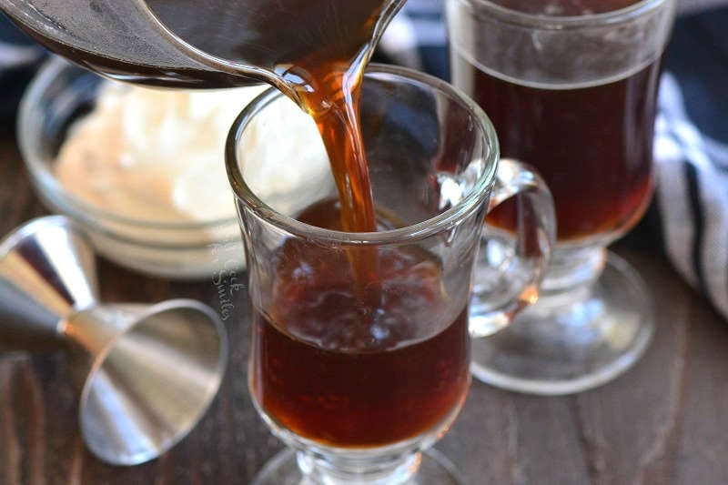 pouring in coffee into the glass mug.