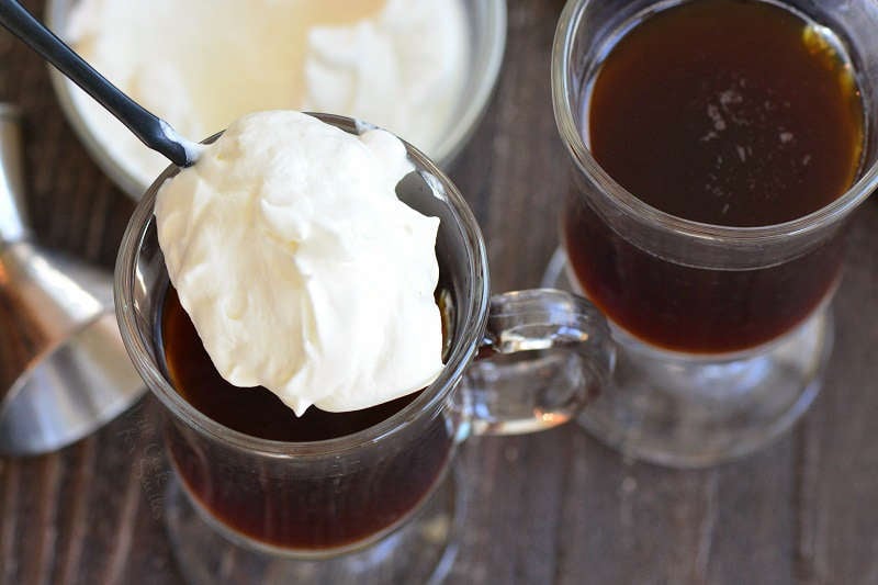 adding homemade whipped cream to the coffee.