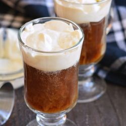 two glass mugs with coffee and whipped cream.
