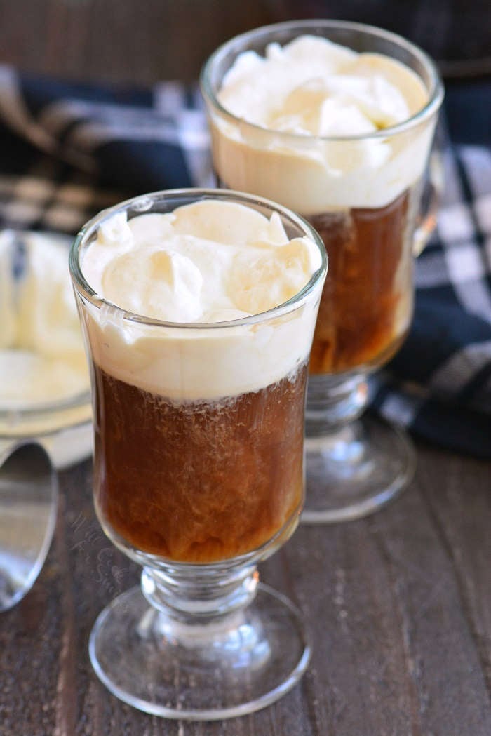two glass mugs with coffee and whipped cream.