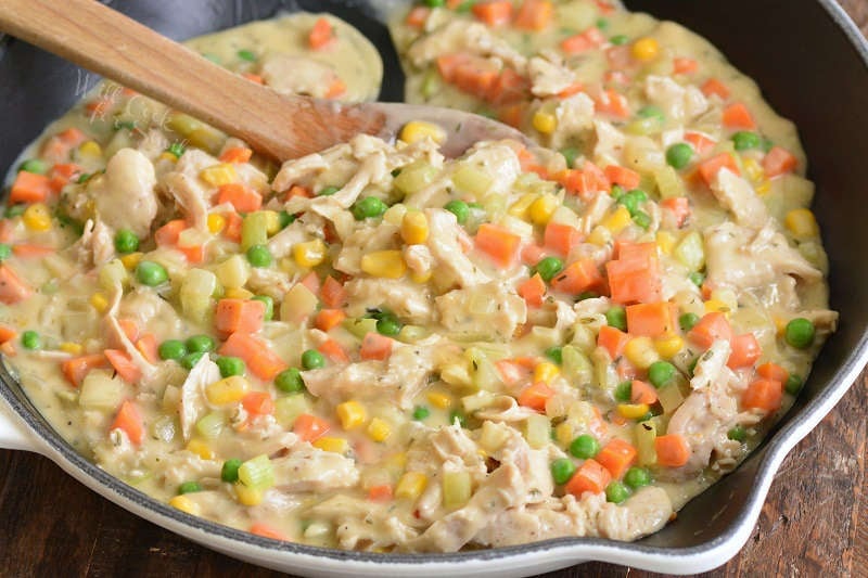 stirring in turkey and sauce for the pot pie in the skillet.
