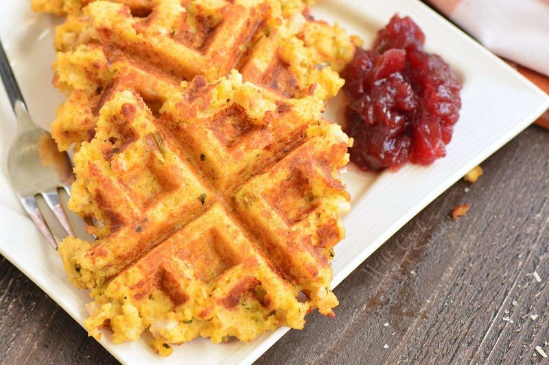 closeup of a stuffing waffles with some cranberry sauce on a plate.