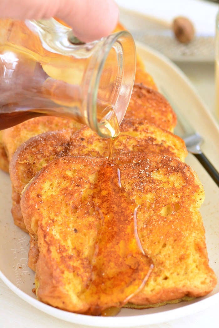 maple syrup over eggnog French toast on a serving platter 
