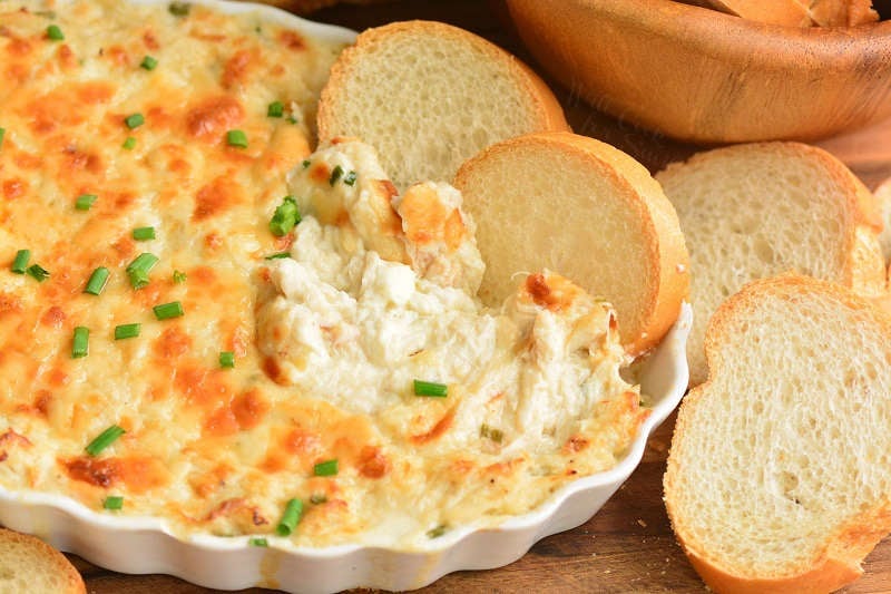 crab dip with bread slices on a cutting board 