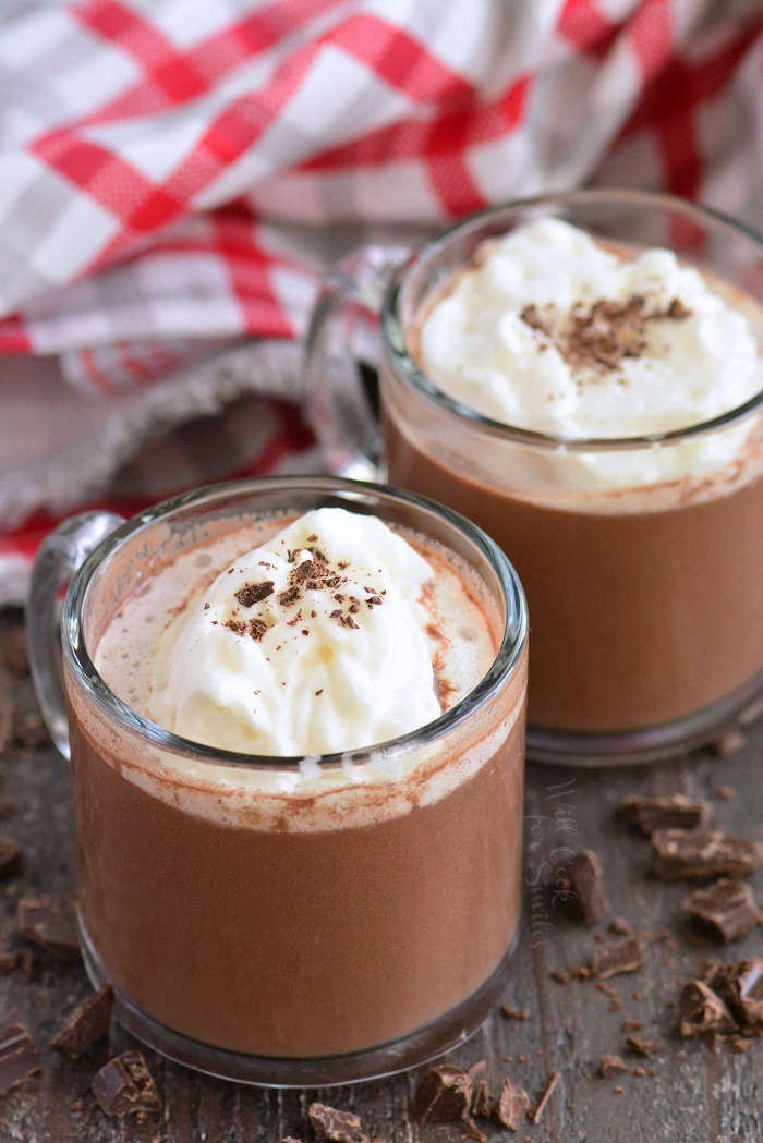 hot chocolate horizontal in glass mugs on a wood cutting board 