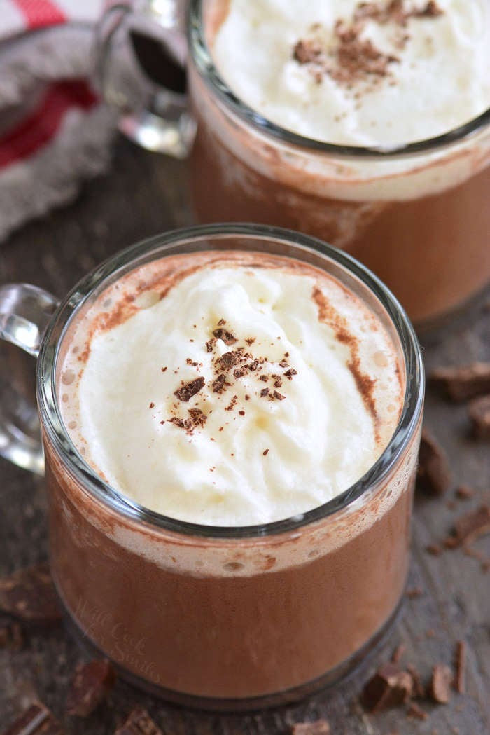 glass mug full of red wine hot chocolate topped with whipped cream and chocolate shaving.