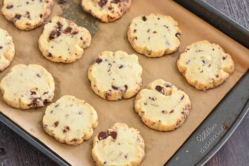 chocolate chunk shortbread cookies on parchment paper on a cookie sheet 