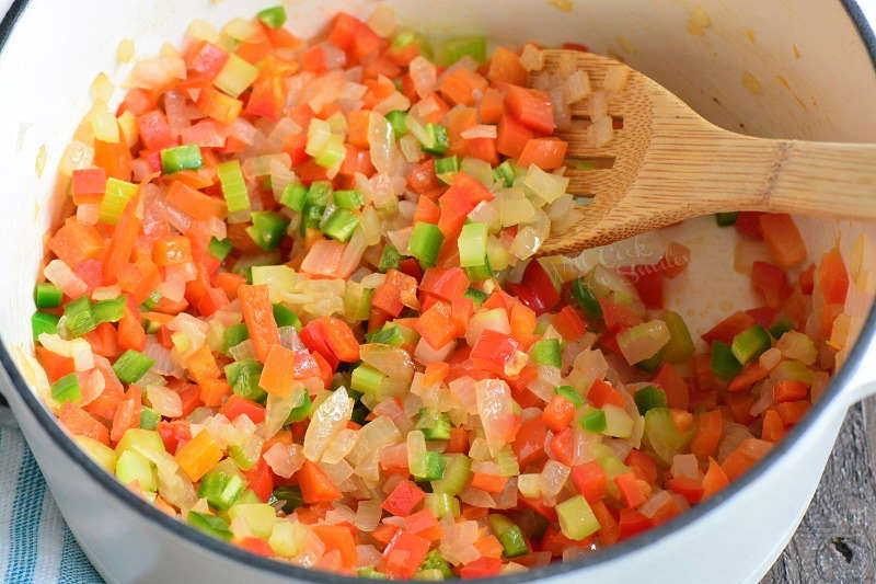 sautéing vegetables in a pot with a wooden spoon 