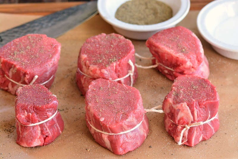 cut, tied, and seasoned steaks before cooking on parchment paper 