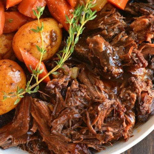 instant pot beef stew on plate with potatoes and carrots with a spring of rosemary 