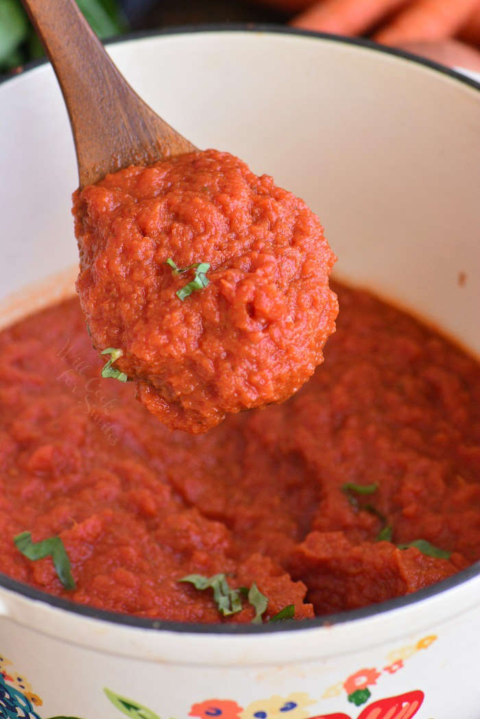 spooning sauce from the pot