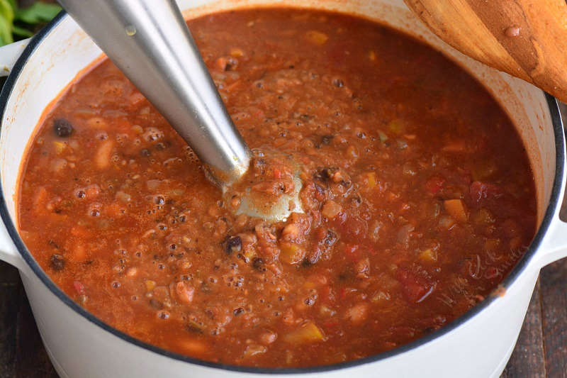 blending chili with immersion blender in the pot 